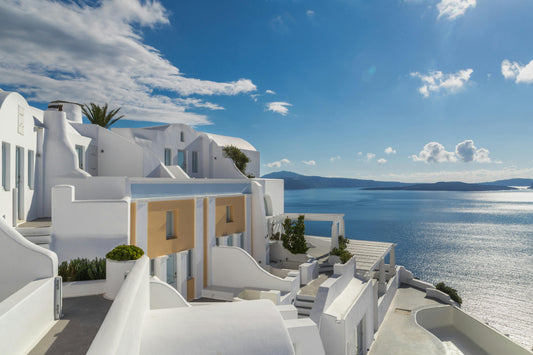 White-washed houses of Santorini overlooking the deep blue Aegean Sea on a bright summer day