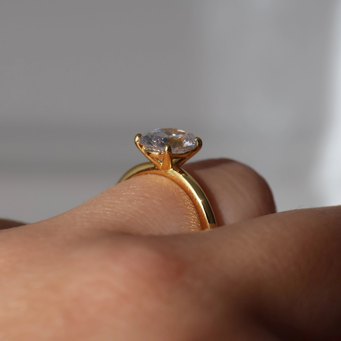 Side view of a 2 carat oval solitaire ring in gold with cubic zirconia