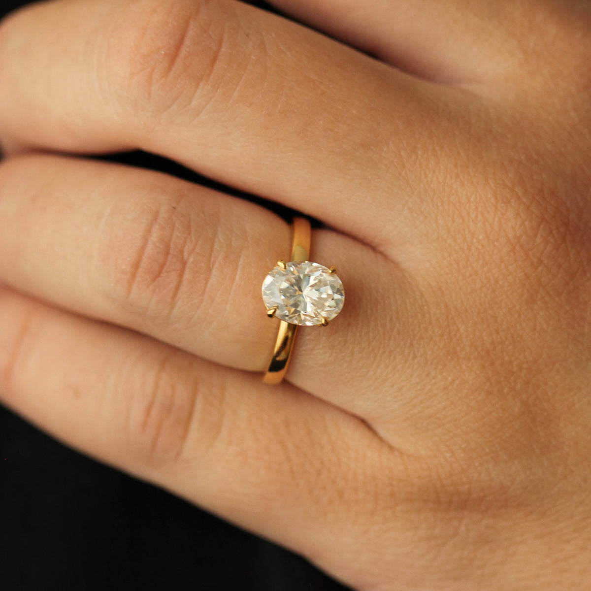 close up of a 2 carat oval solitaire moissanite ring set in 14k gold filled