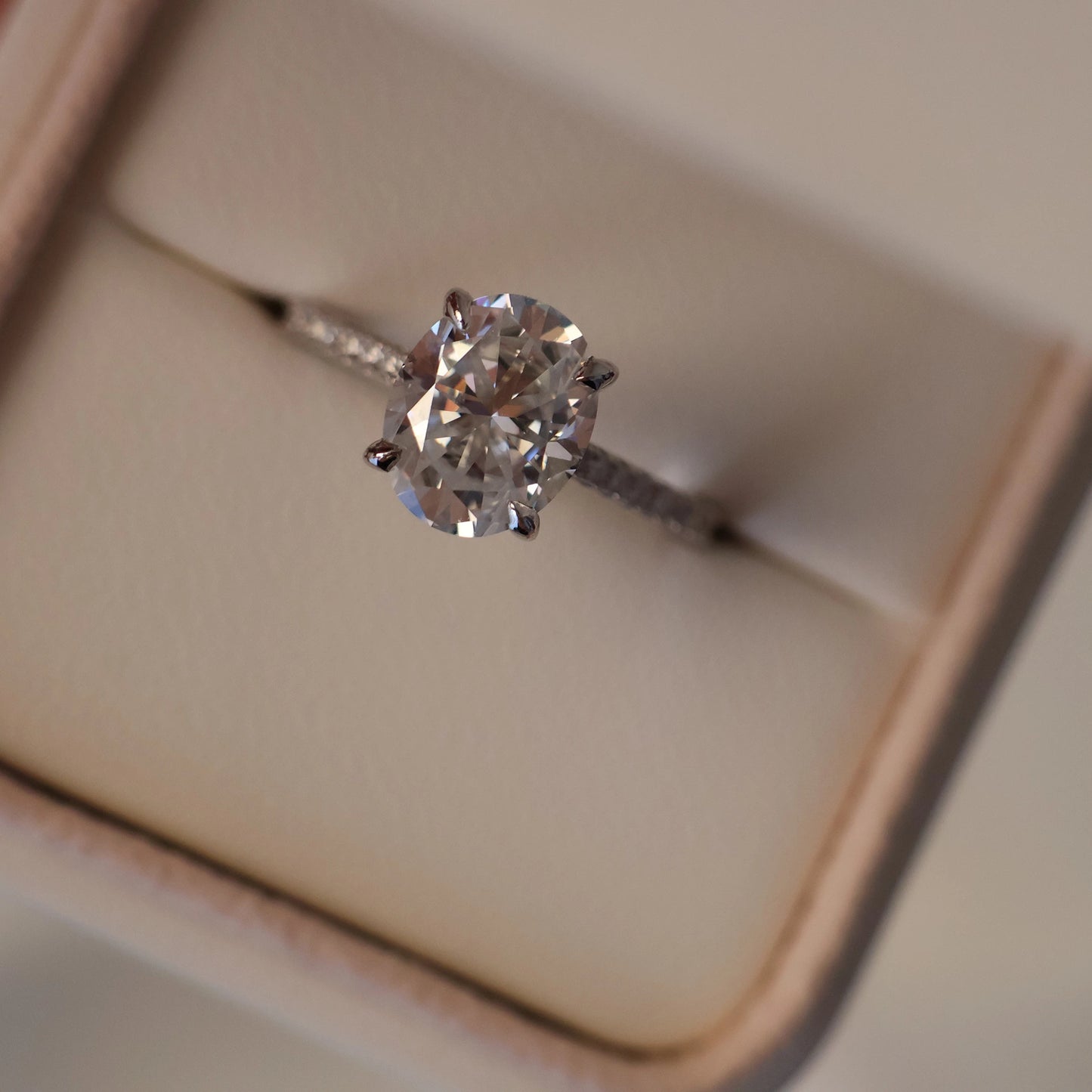 3 carat oval moissanite ring with pave band in silver displayed in a proposal box