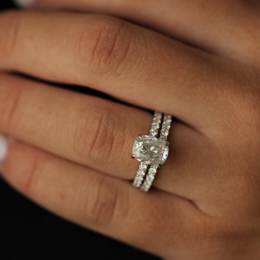 top view of 3 ct elongated cushion moissanite ring and pave eternity band on hand