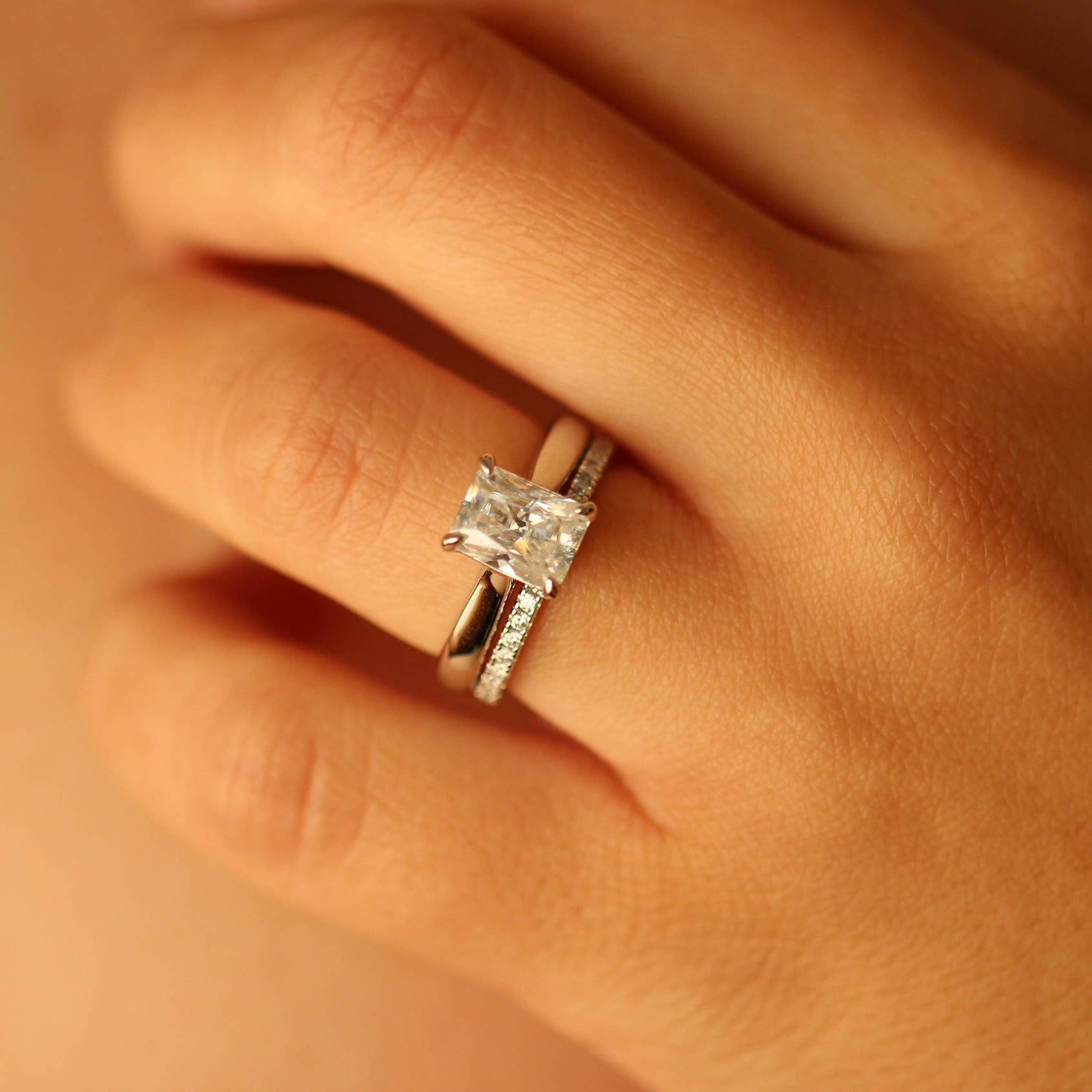 2ct radiant moissanite ring on hand with moissanite pave band