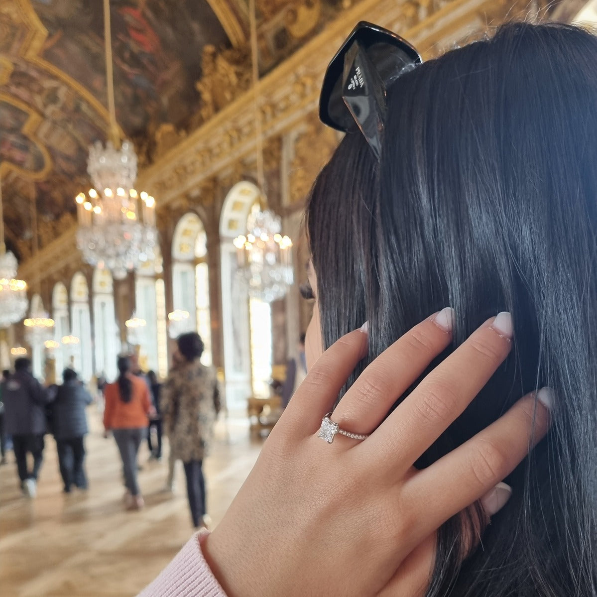 Radiant cut ring on hand in Palace of Versailles