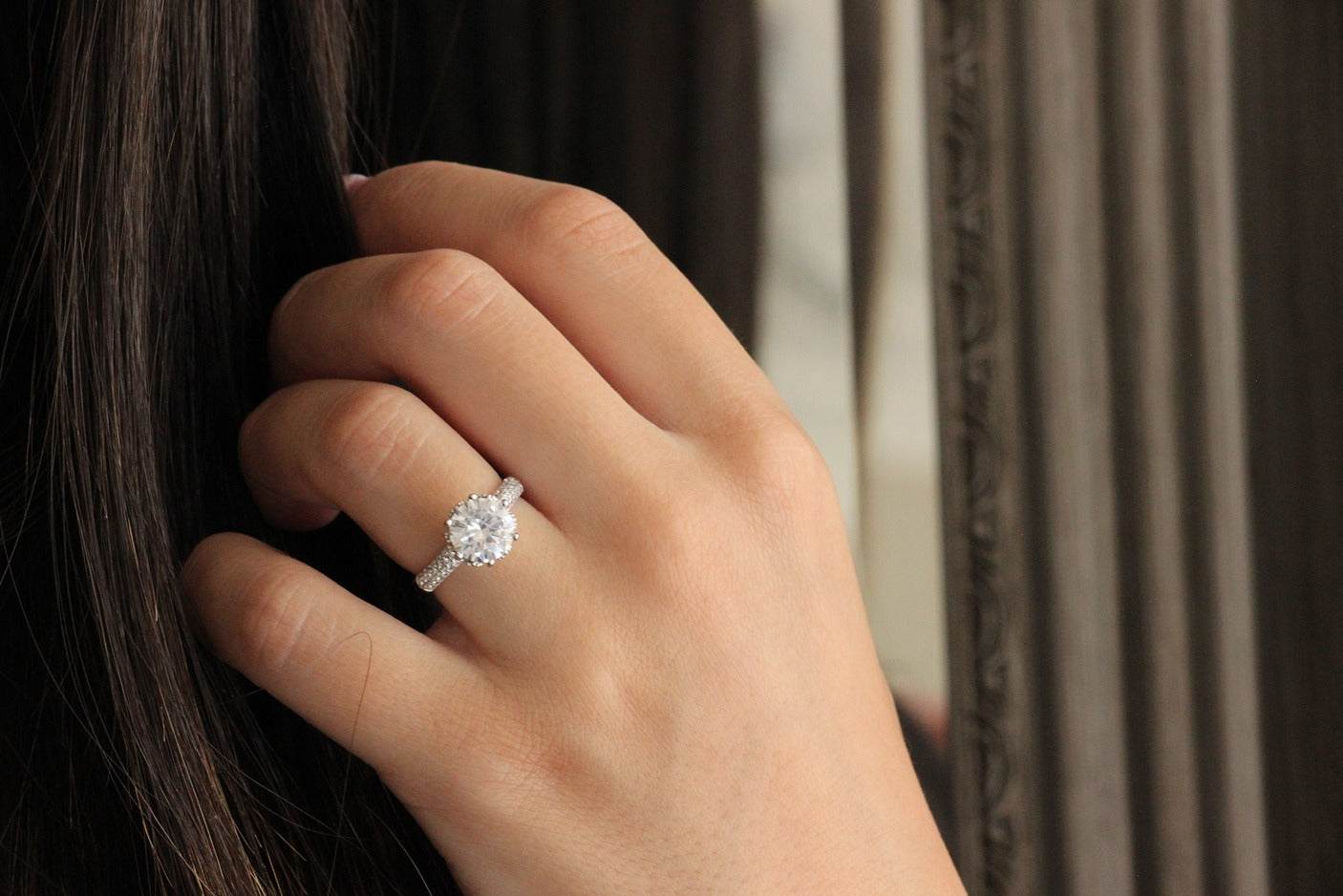 girl holding her hair posing with round silver ring