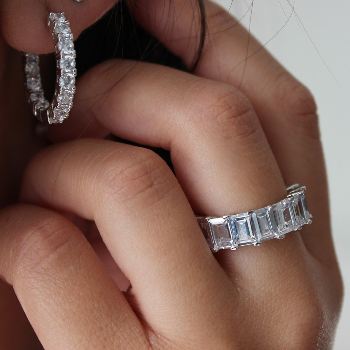 Stterling Silver hoop earrings next to stacker ring