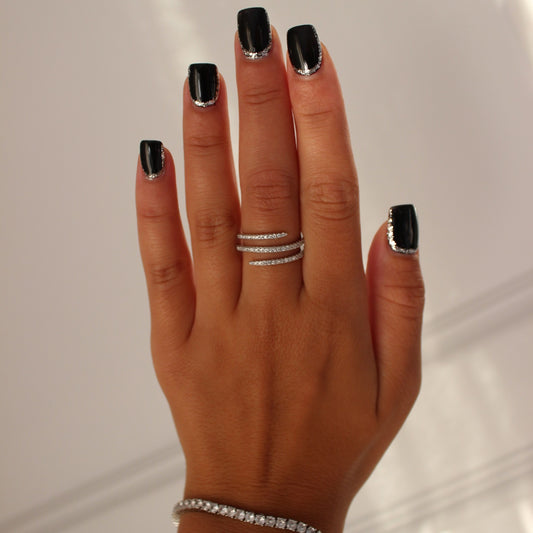 Cairo spiral ring in silver on hand with silver tennis bracelet