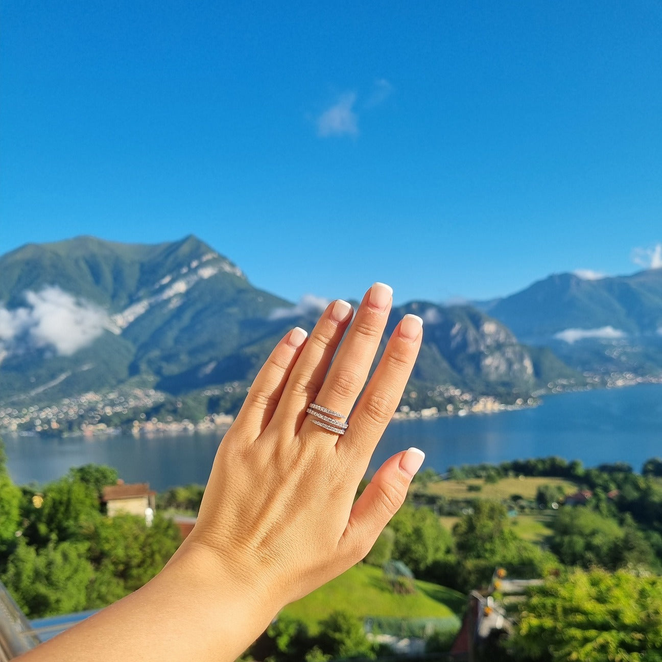 Cairo spiral ring in silver on hand in front of Lake Como