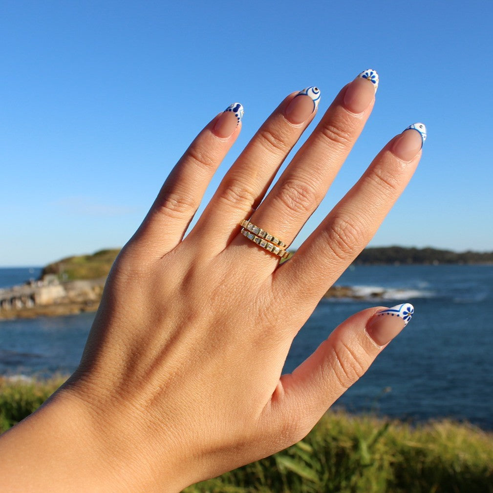 Como spiral gold ring on hand at La Perouse Beach, Sydney