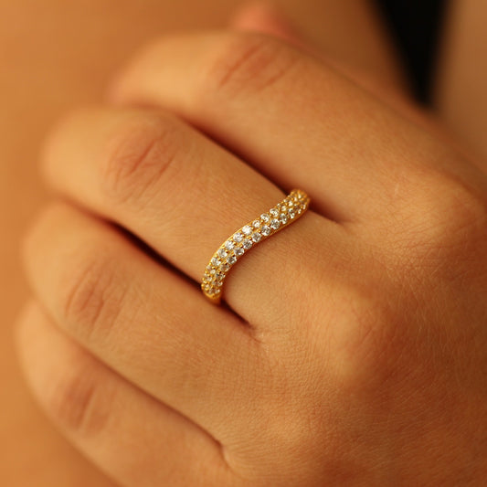 Gold curved pave ring on hand
