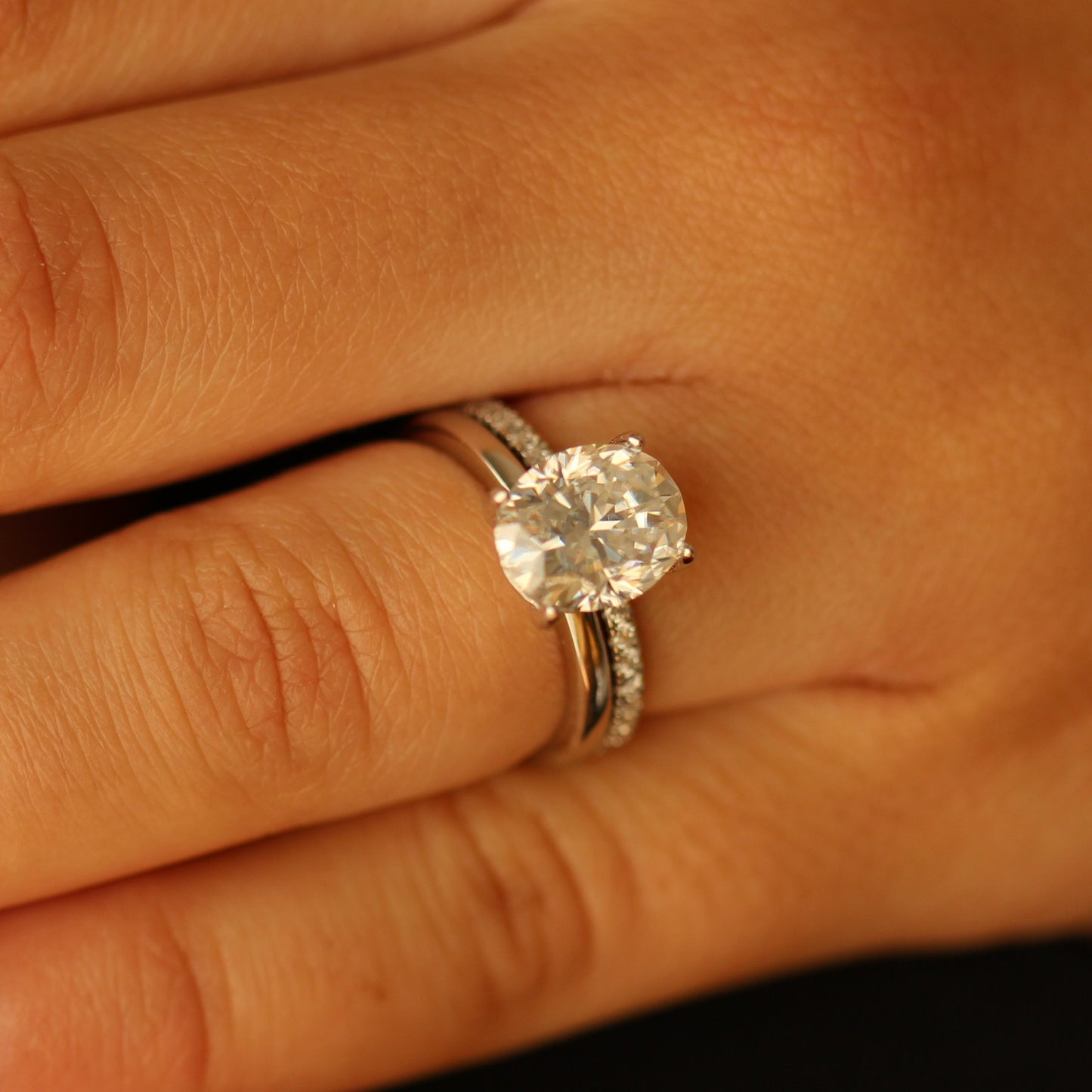 3ct oval moissanite ring on hand with silver pave band