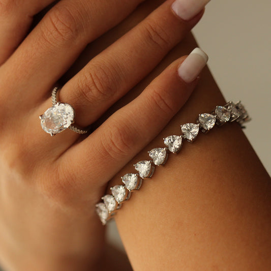 Heart tennis bracelet on hand with cubic zirconia ring