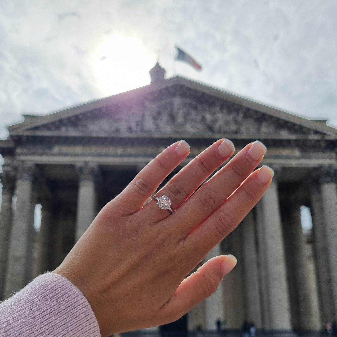 Round cut ring on hand in front of Pantheon Paris