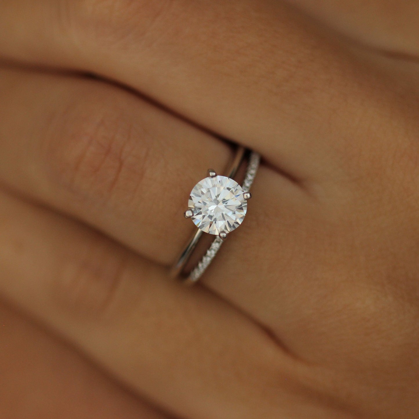 Round cut ring and 1mm pave wedding band on hand