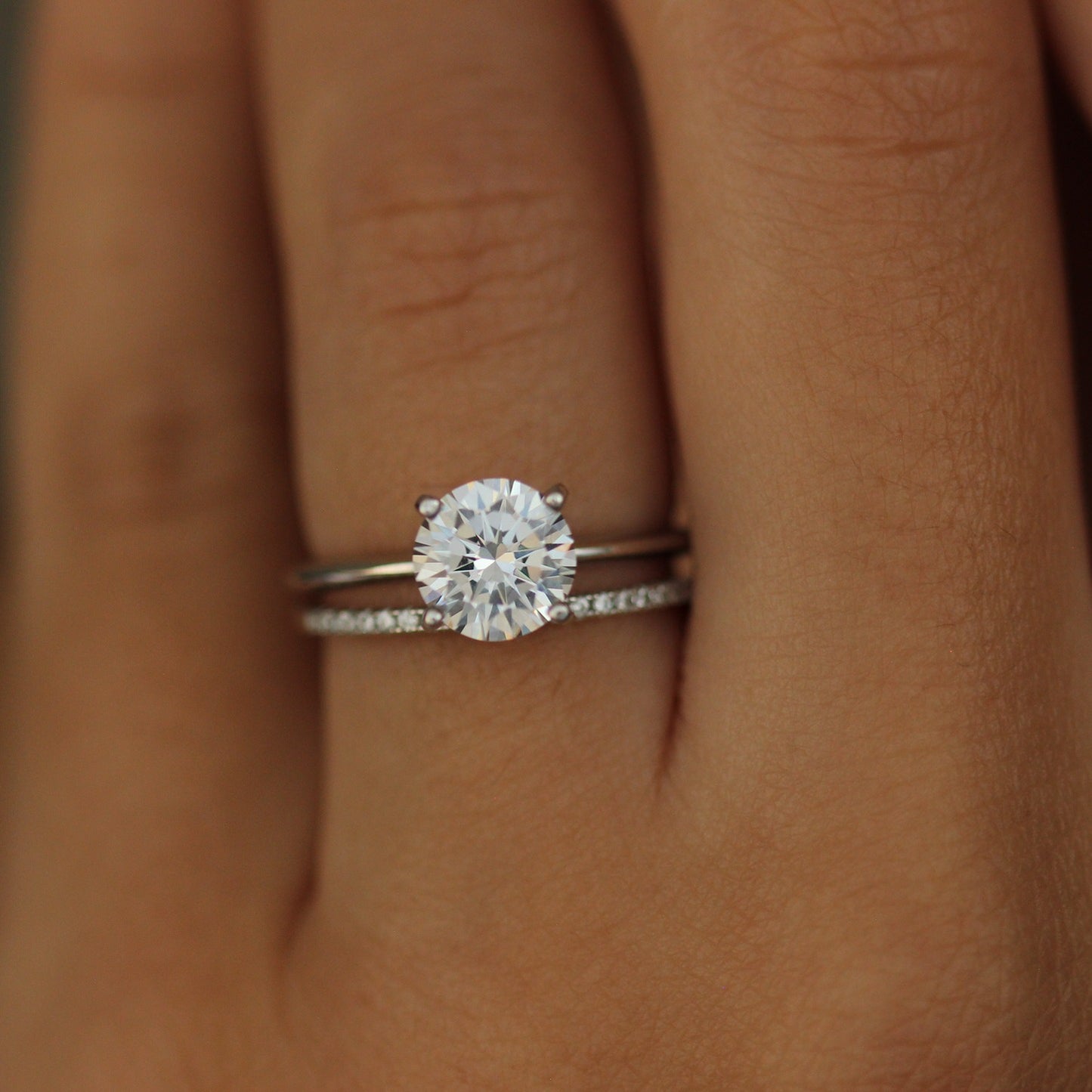 Round cut ring and 1mm pave wedding band on hand