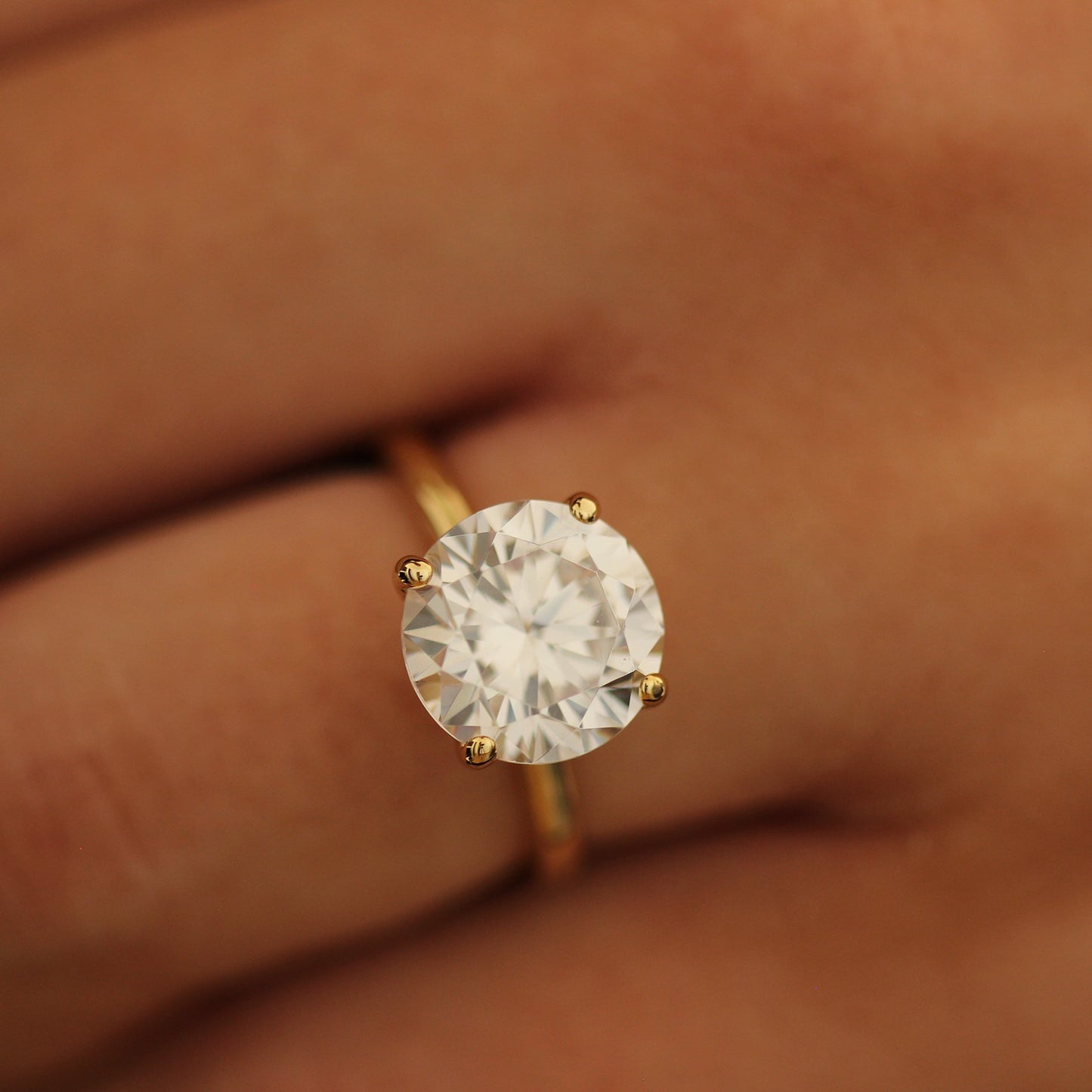 4ct round cut ring on a person's finger