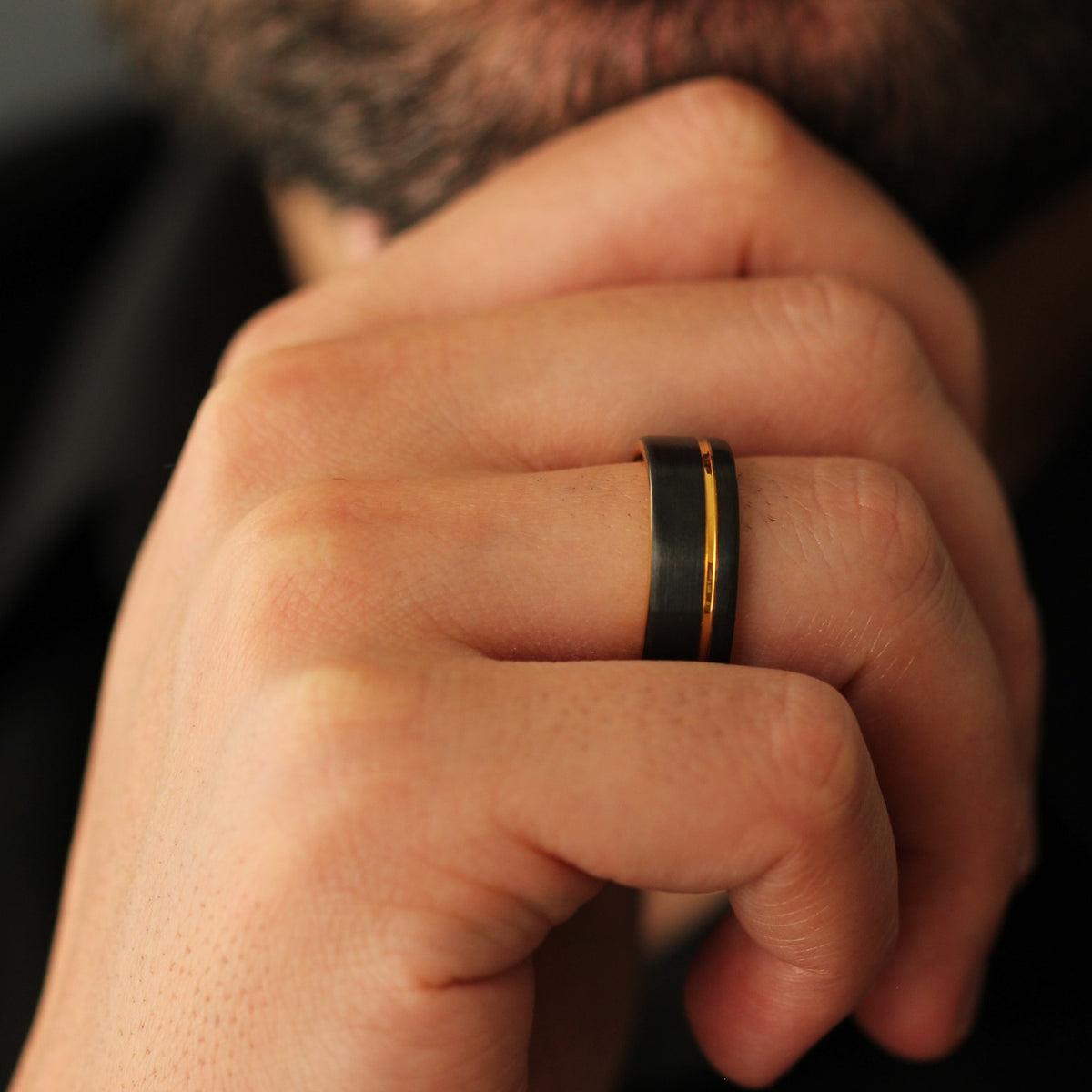 Men’s black and gold ring with an offset line detail