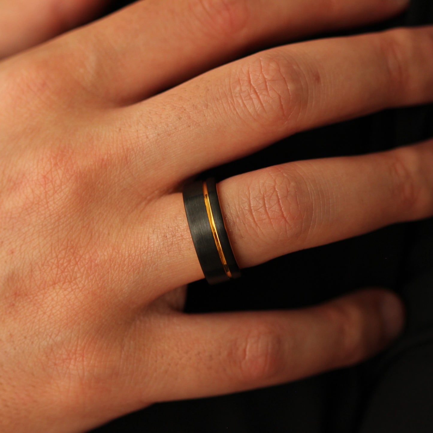 “Men’s black wedding band with a gold offset line accent
