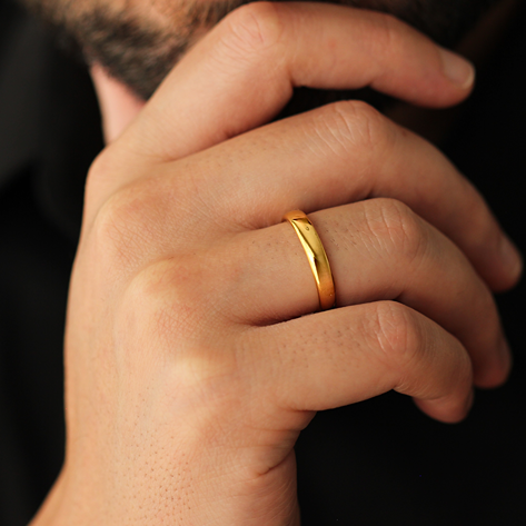 polished gold wedding band 4mm width on man's hand touching chin