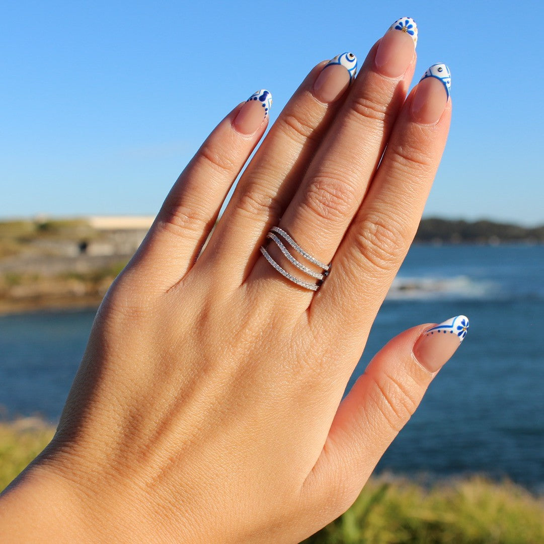 Triple row pave ring on hand at La Perouse Beach, Sydney