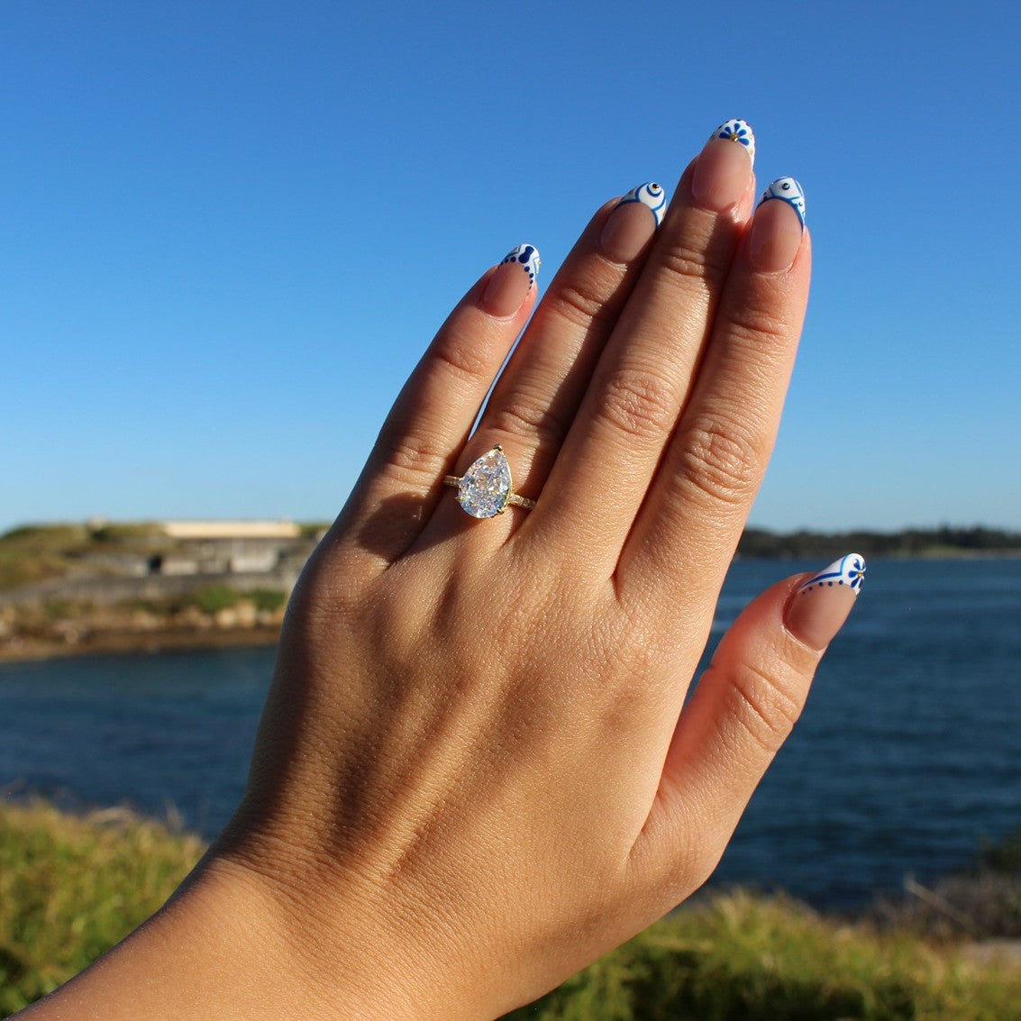 Seville gold pear ring on hand at La Perouse Beach, Sydney