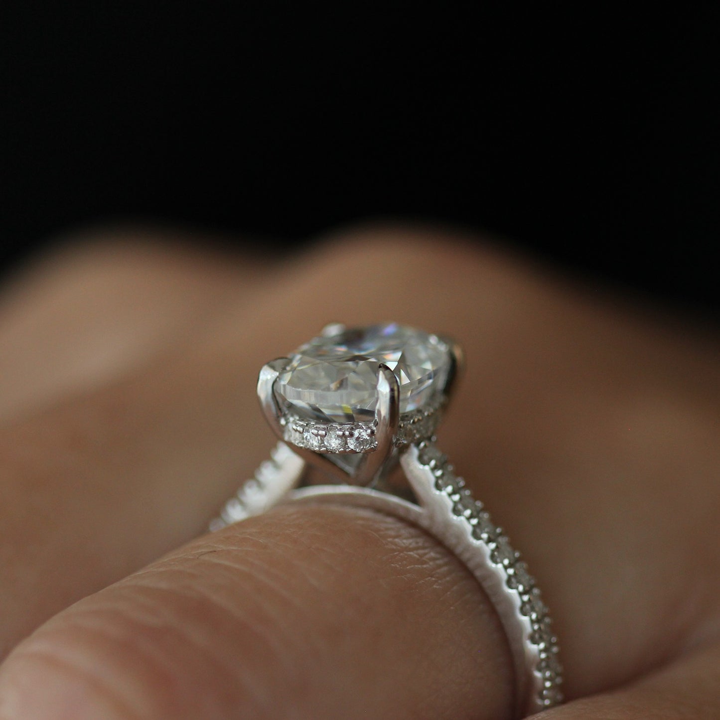 Side view of 3ct oval moissanite ring with pave band