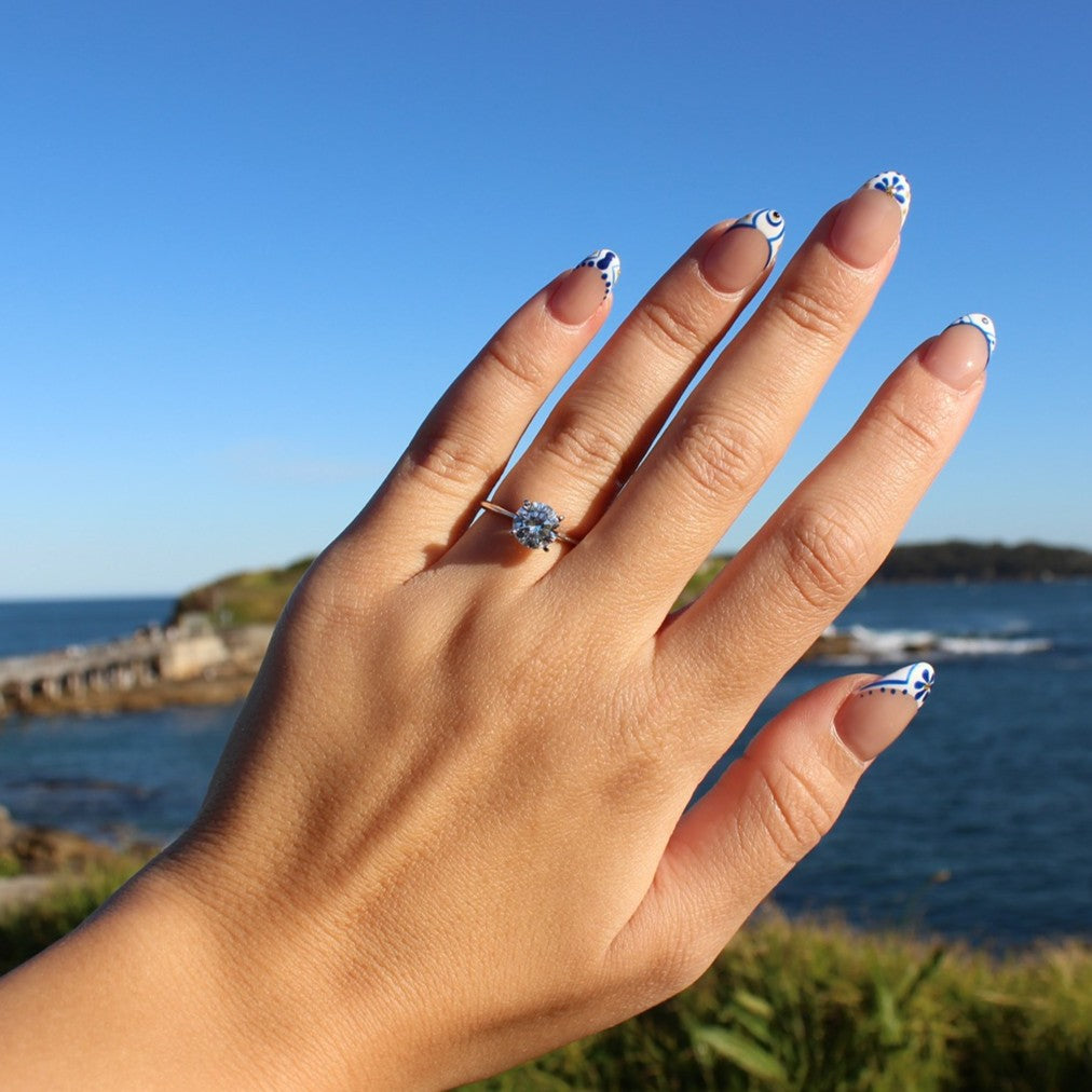 Round cubic zirconia ring on hand at La Perouse Beach, Sydney