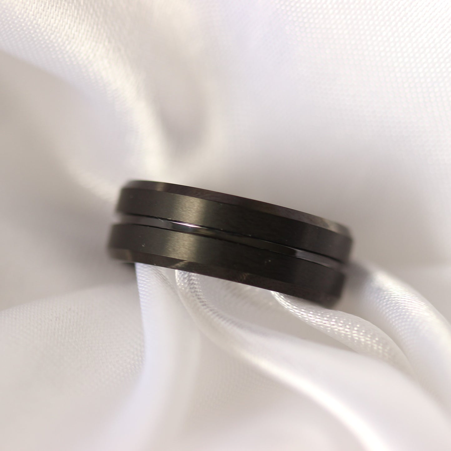 black men's ring on white satin background