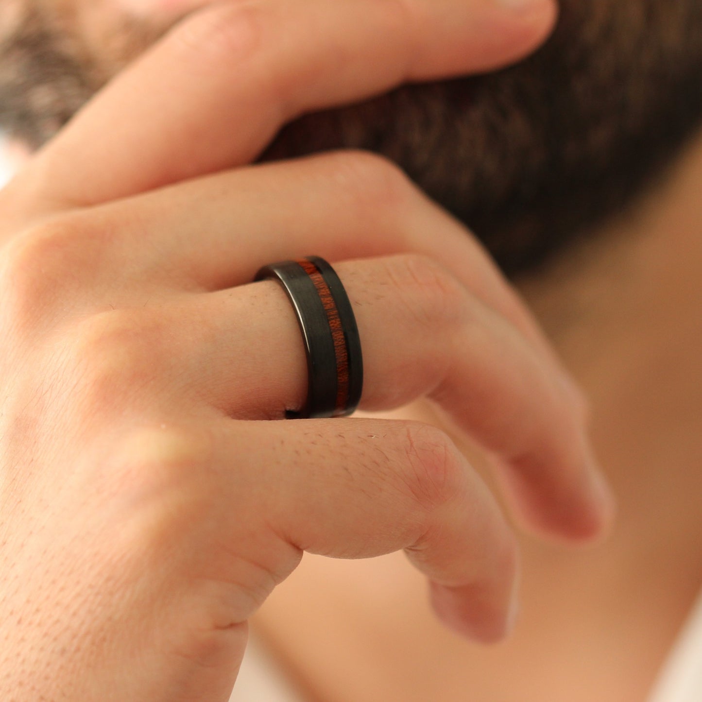 Black men’s ring with natural wood inlay 8mm on male model touching chin