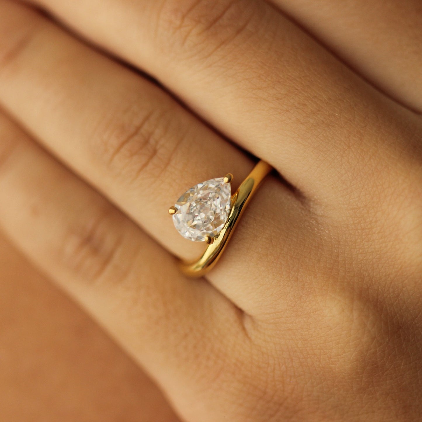 east west facing curved pear ring in gold