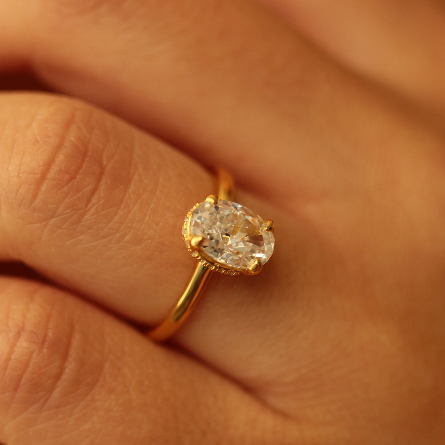 Gold oval ring on finger