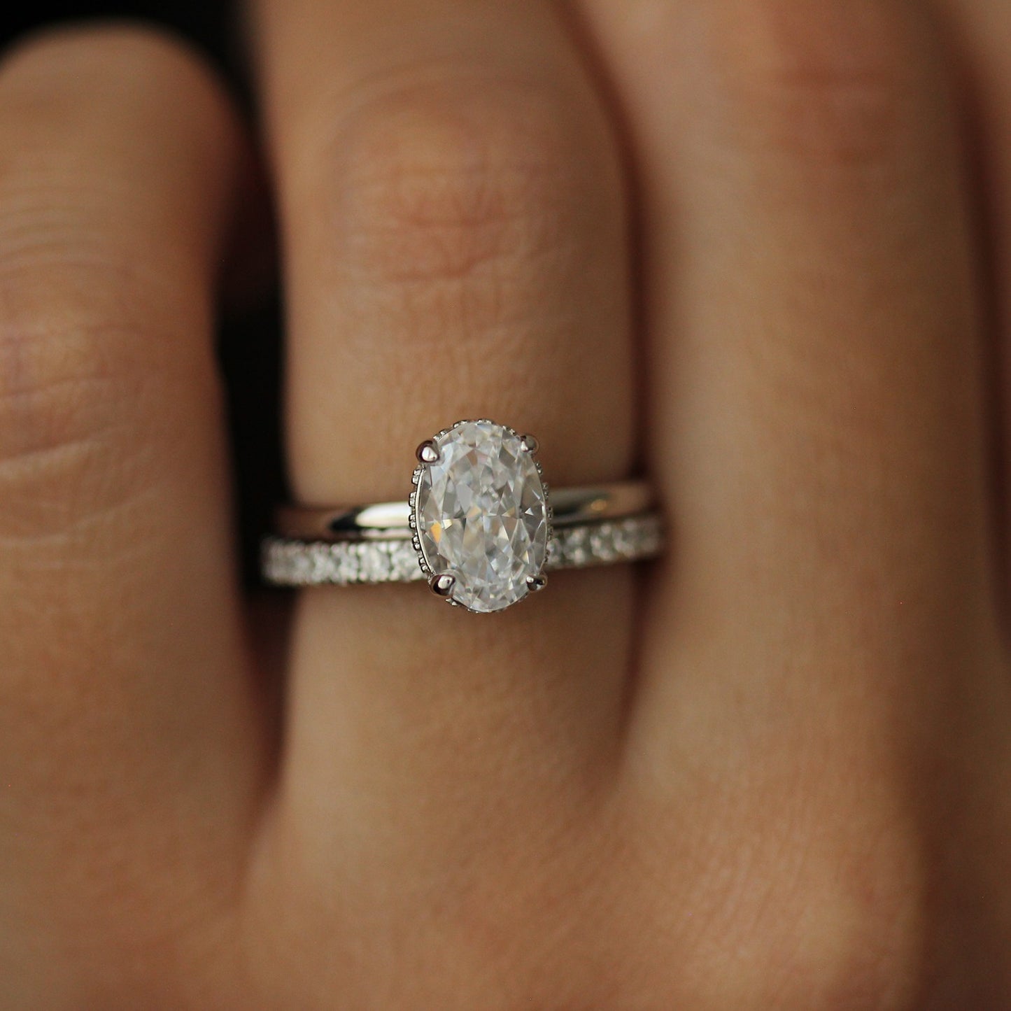 Silver oval ring on hand with pave eternity band