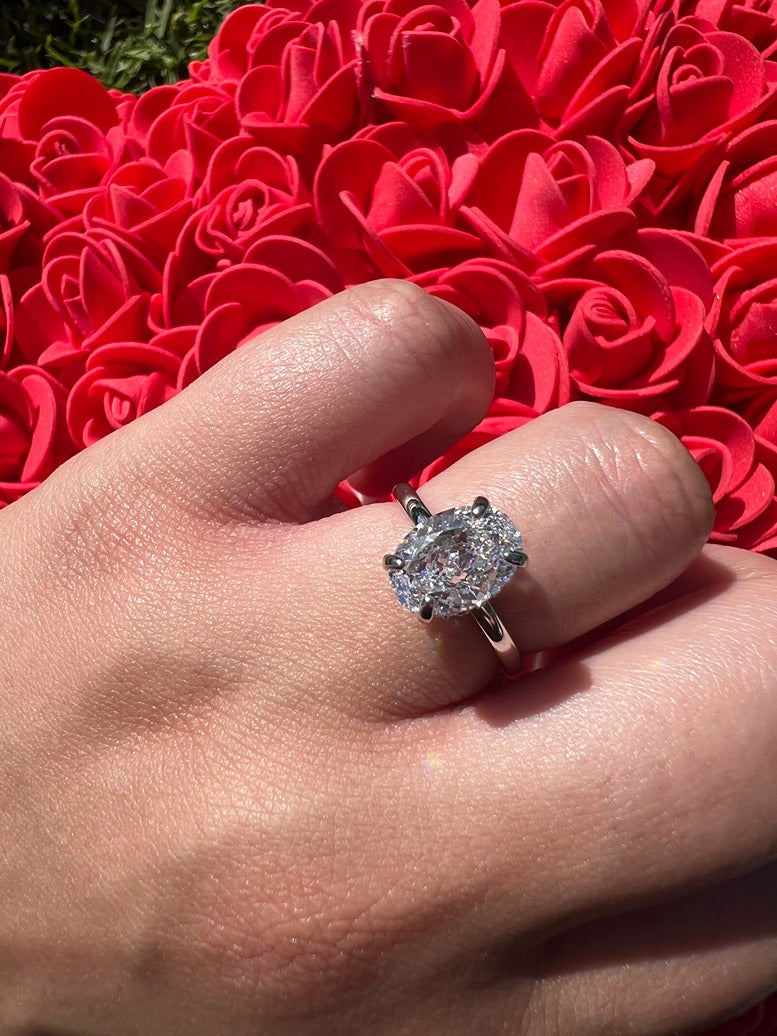 silver oval ring with flower pillow in background