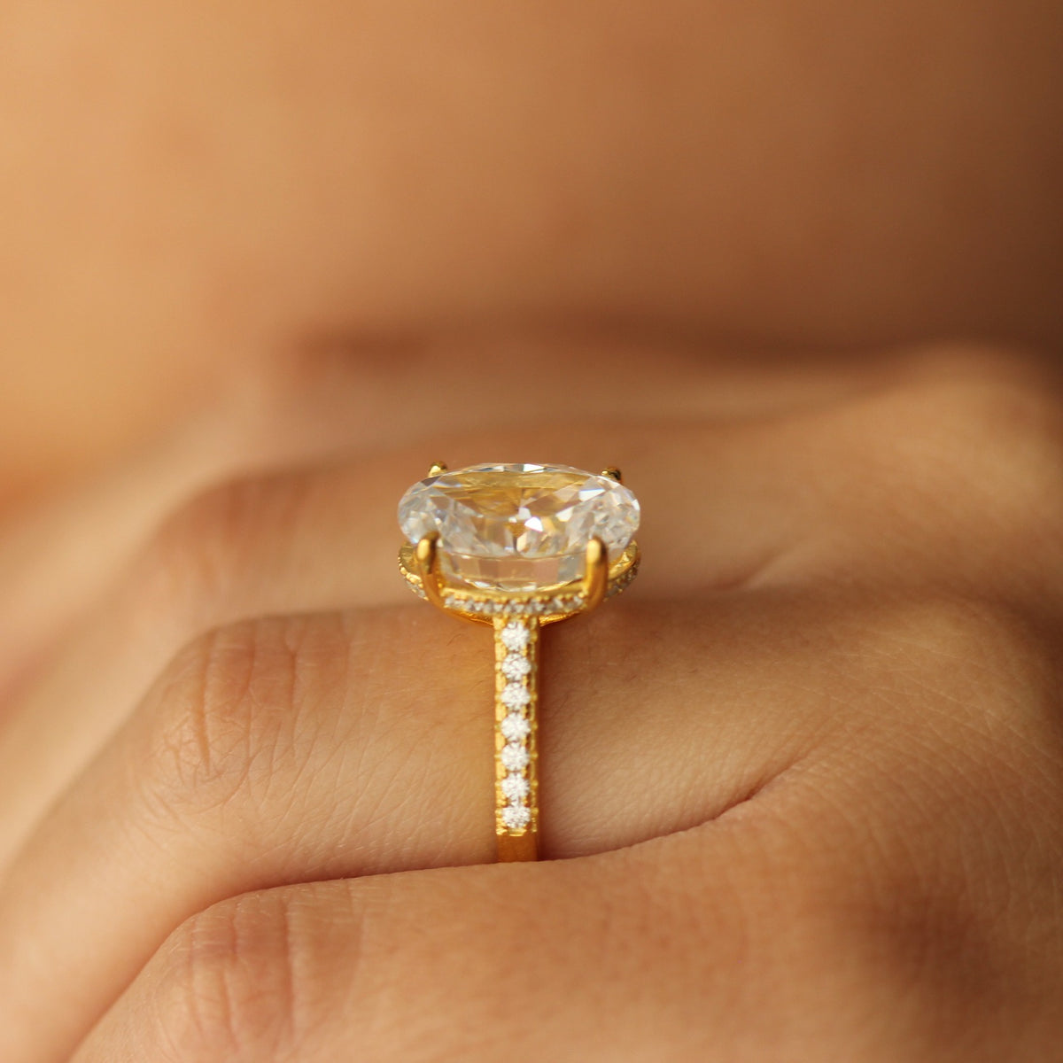 4 carat gold oval ring on pave band on hand side view