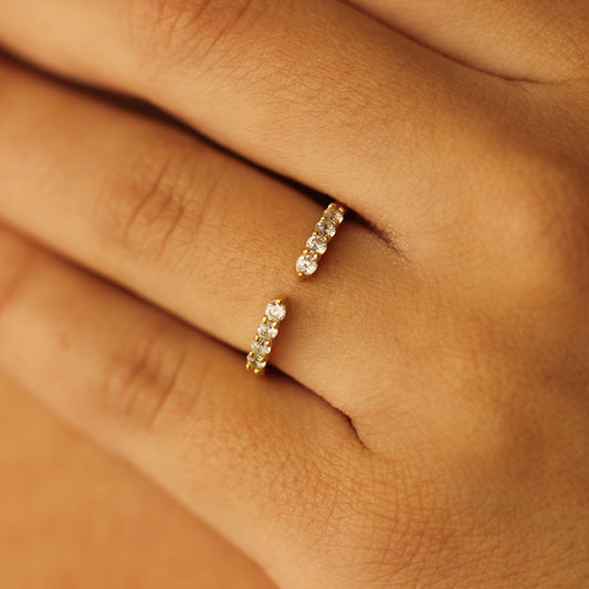 open gold wedding band with round cz stones on hand