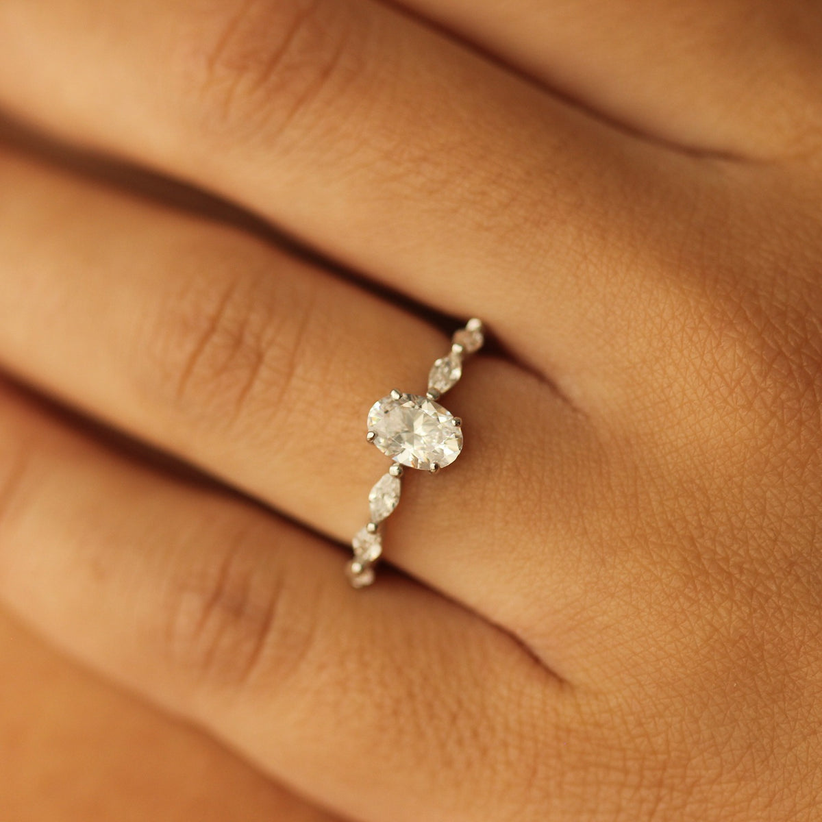 oval fake engagement ring in silver on marquise floating band on white background