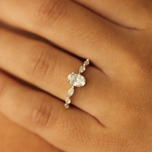 oval fake engagement ring in silver on marquise floating band on white background