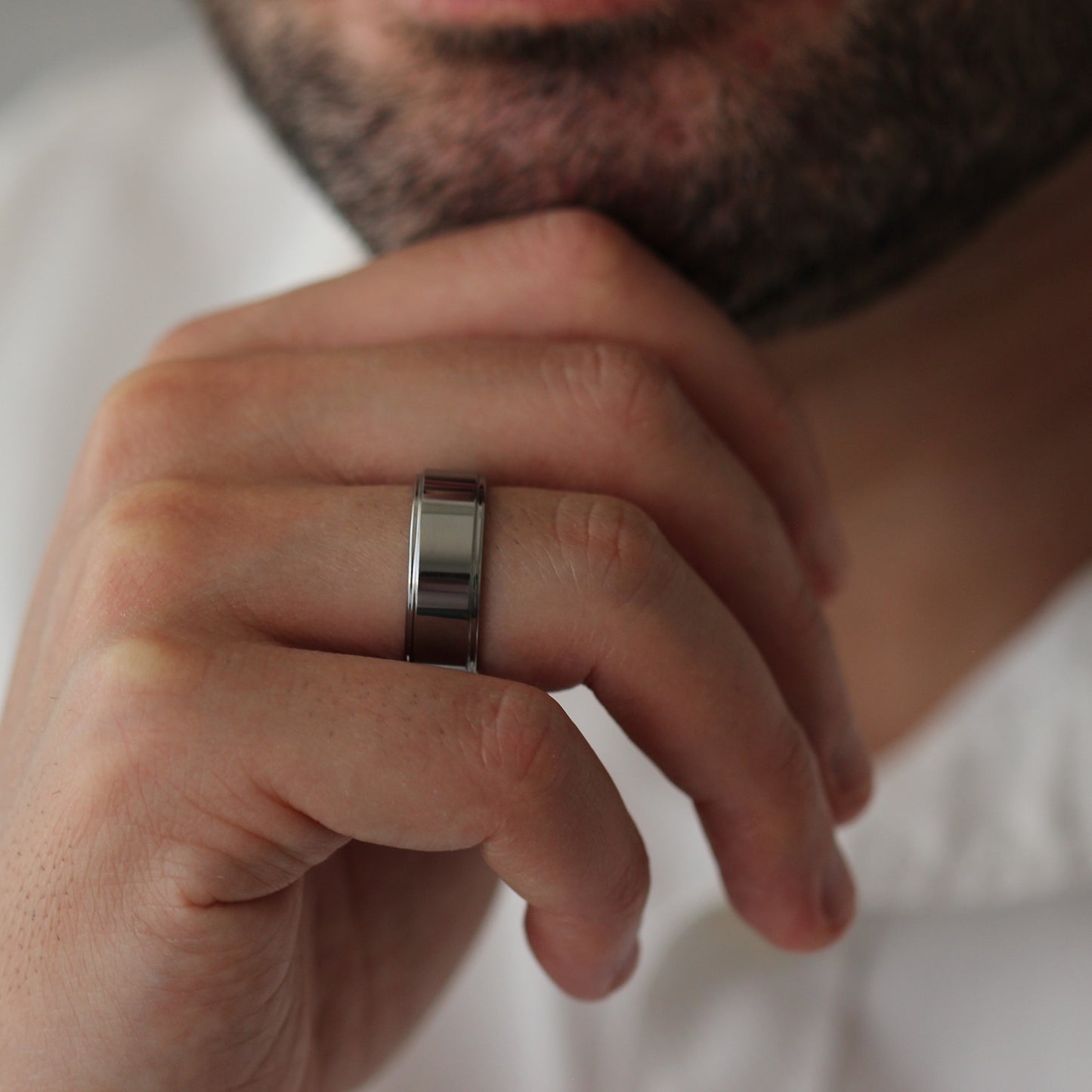 Polished silver men’s wedding band with stepped edges