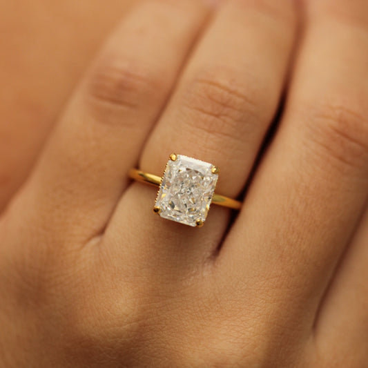 gold radiant cut ring with 4 carat centre stone on hand