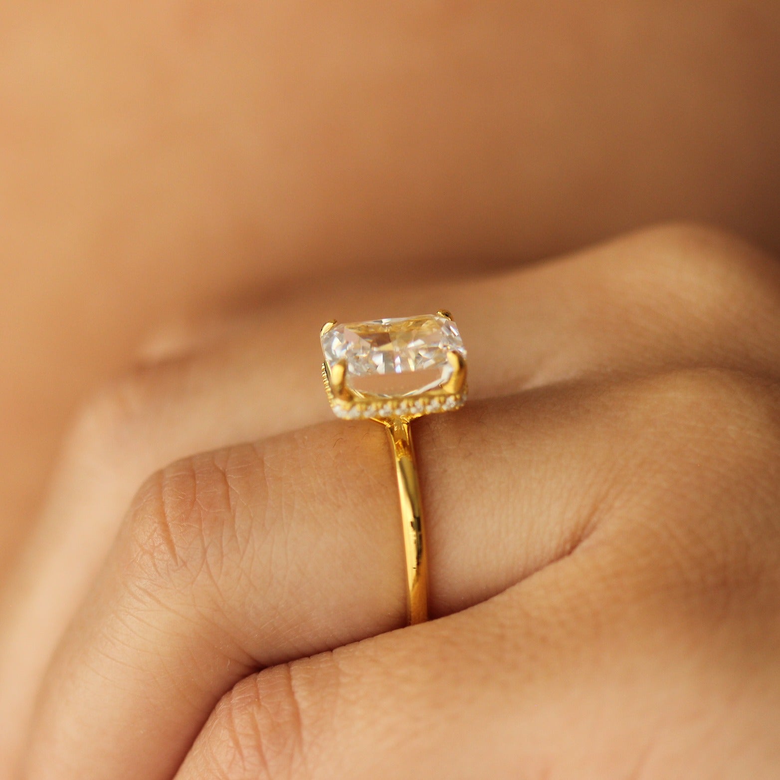 radiant cut gold ring with 4 carat centre stone on hand side profile