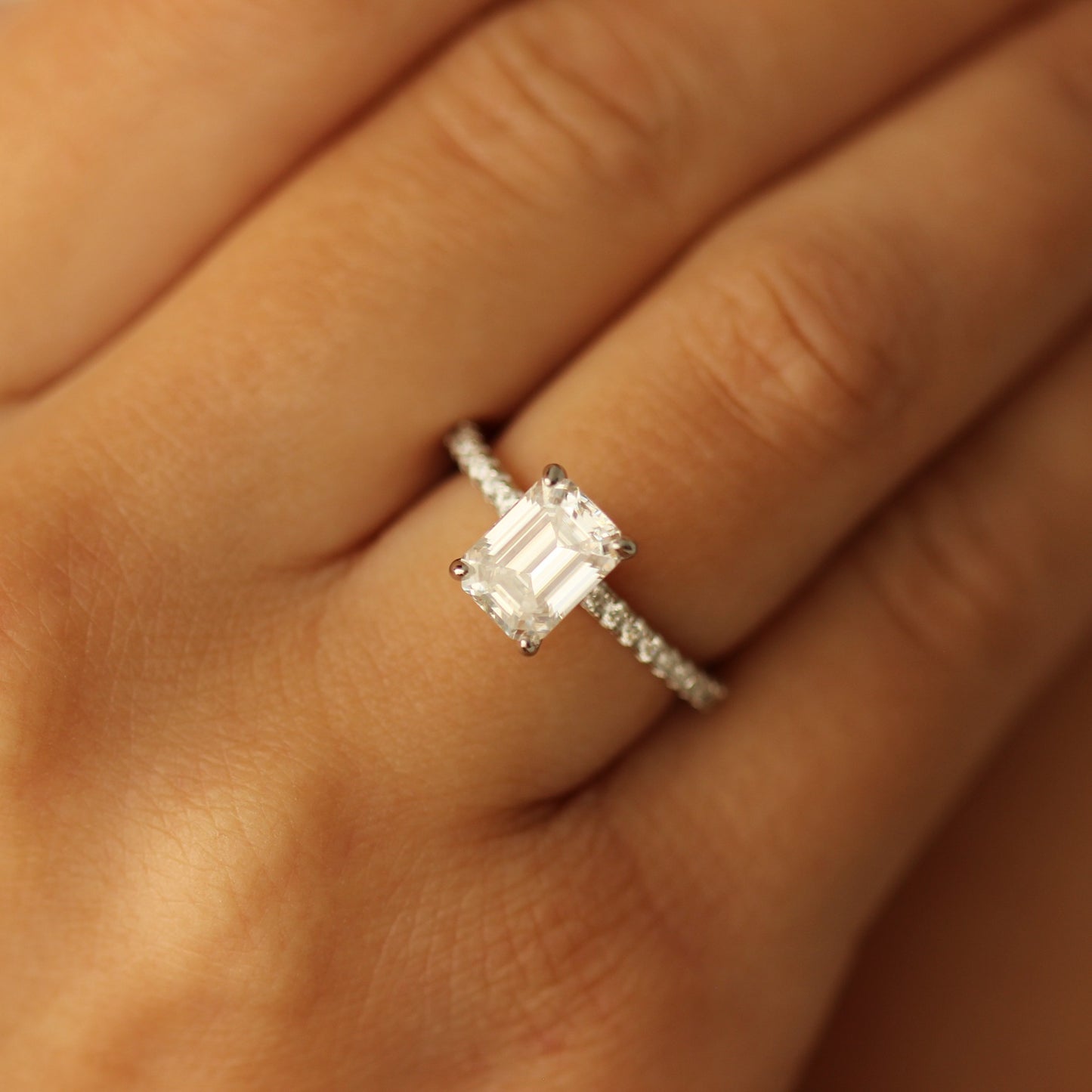 seoul emerald moissanite ring on half pave band on hand
