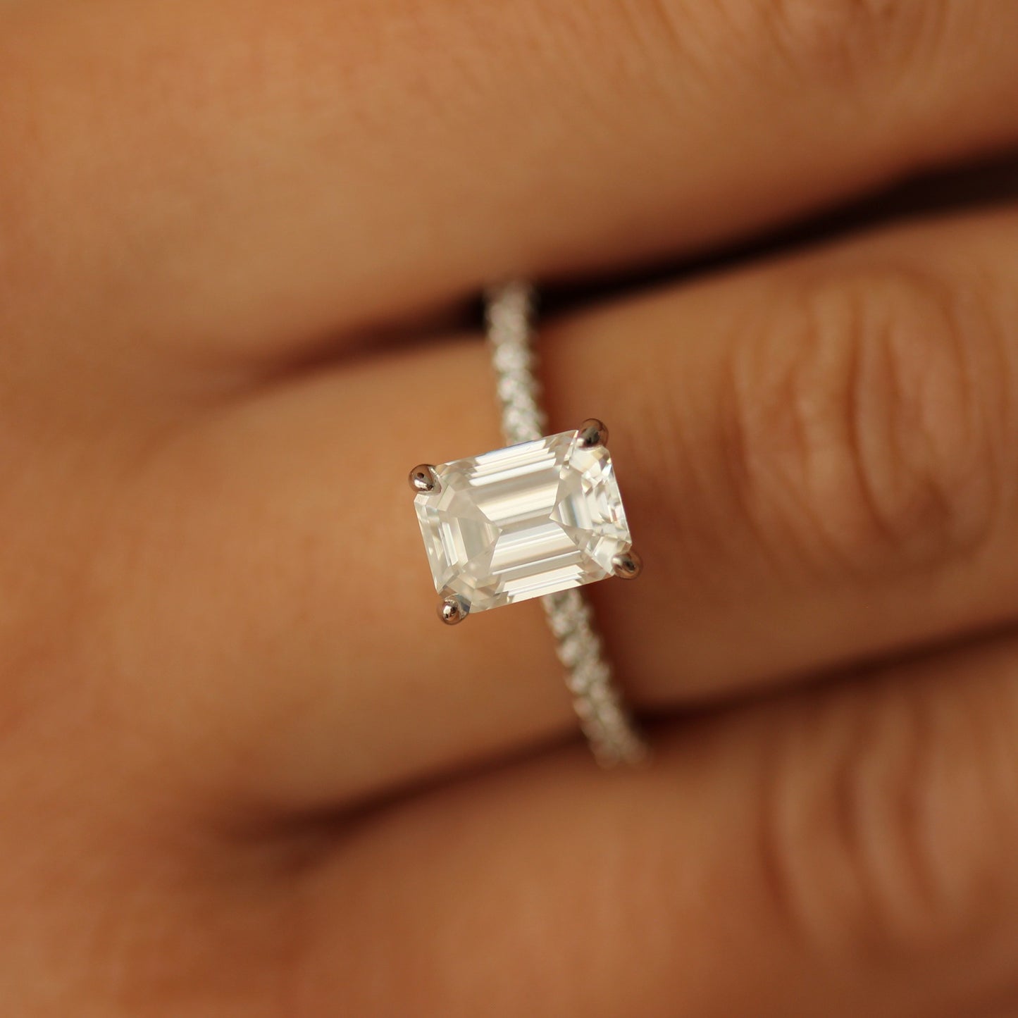 seoul emerald moissanite ring on half pave band on hand