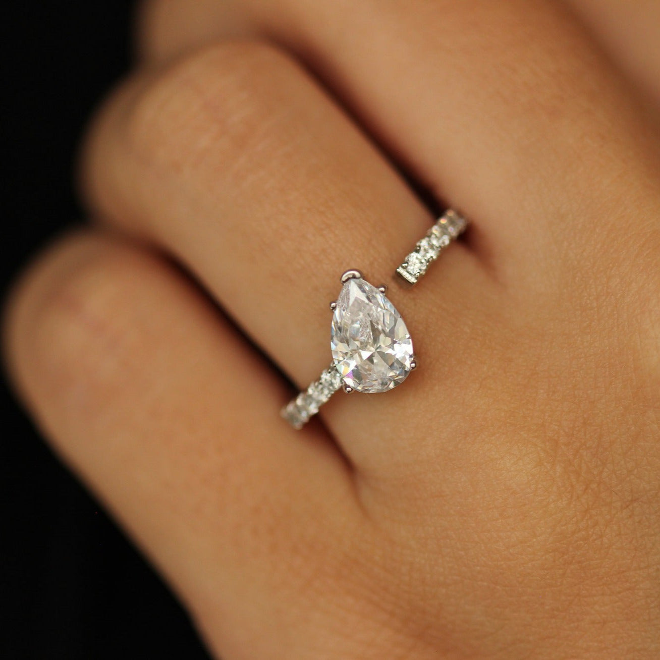 silver adjustable ring with pear stone that is tilted on an angle