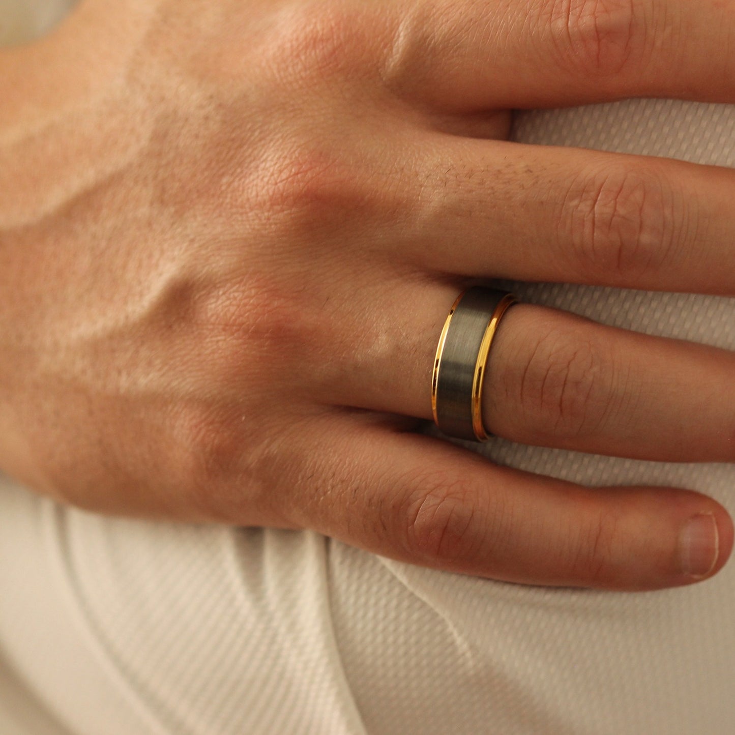 Male model with arms crossed wearing Silver and Gold Men’s Ring 8mm stepped edge