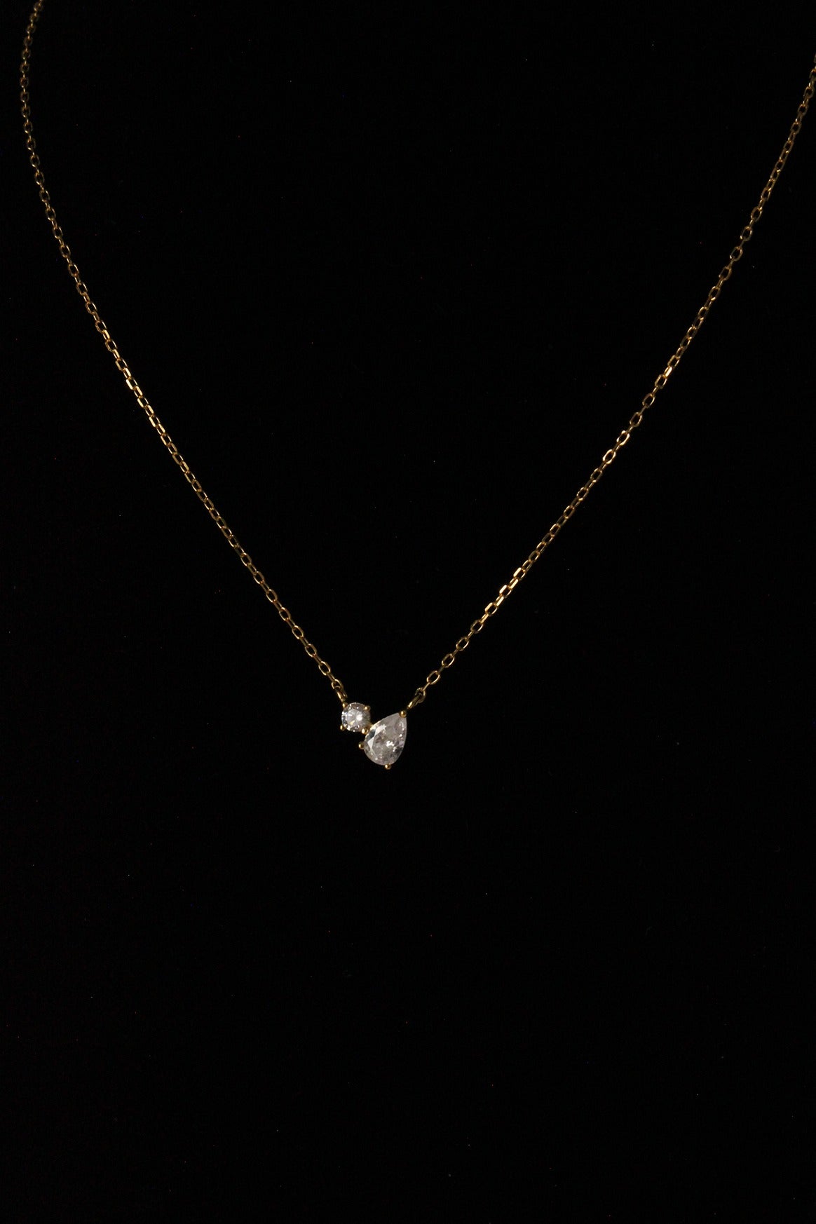 Toi et Moi Necklace Pear and Round Pendant Design on black background