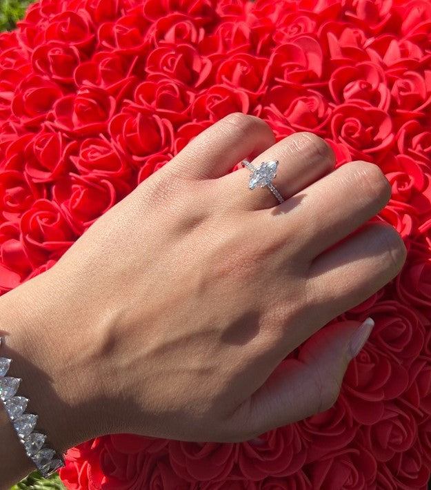 marquise ring with cz stones on silver band on a rose pillow