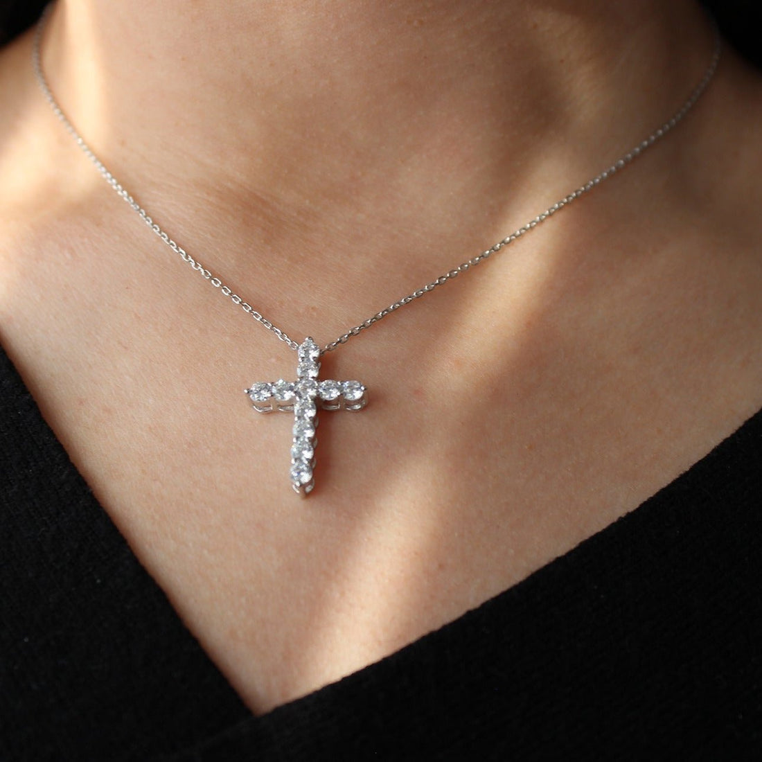 lady wearing silver cross necklace to show its significance