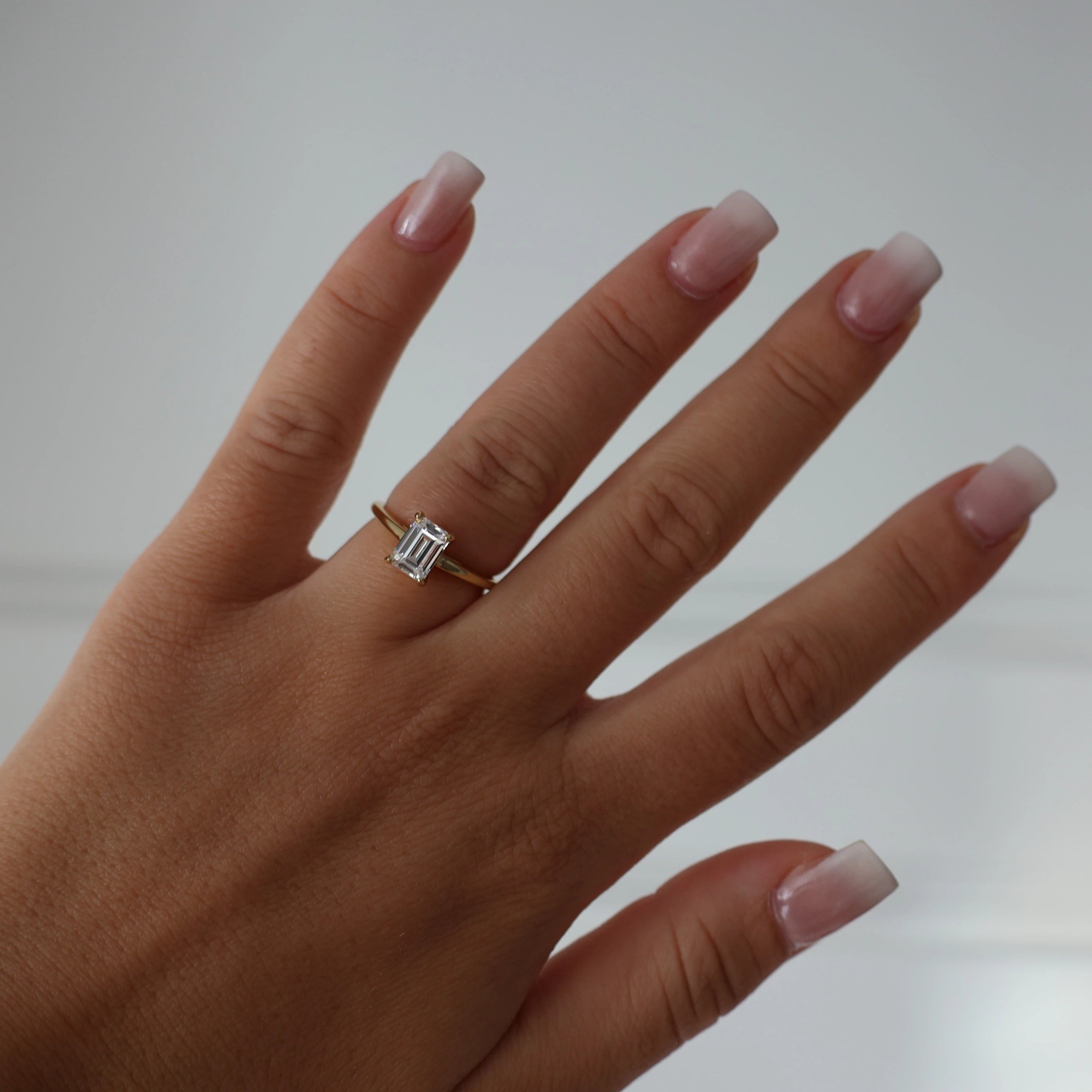 Gold solitaire ring with 1 carat emerald cut cubic zirconia