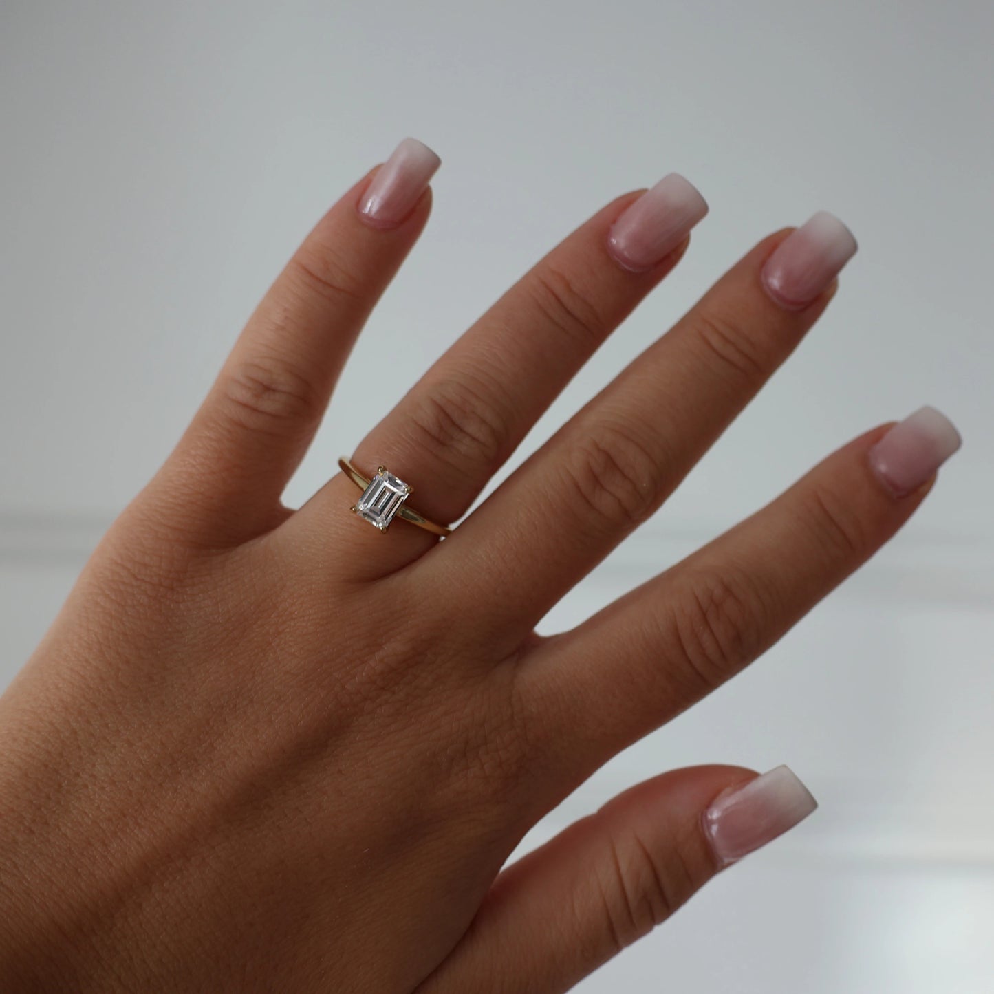 Gold solitaire ring with 1 carat emerald cut cubic zirconia