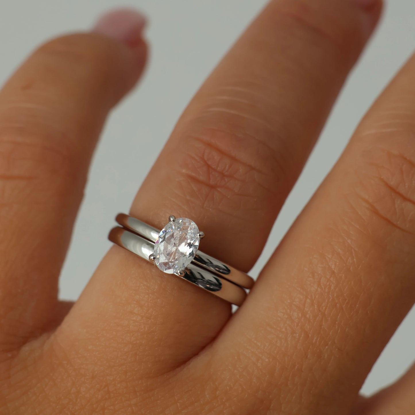 1 carat oval cut cubic zirconia ring stacked with a matching silver wedding band