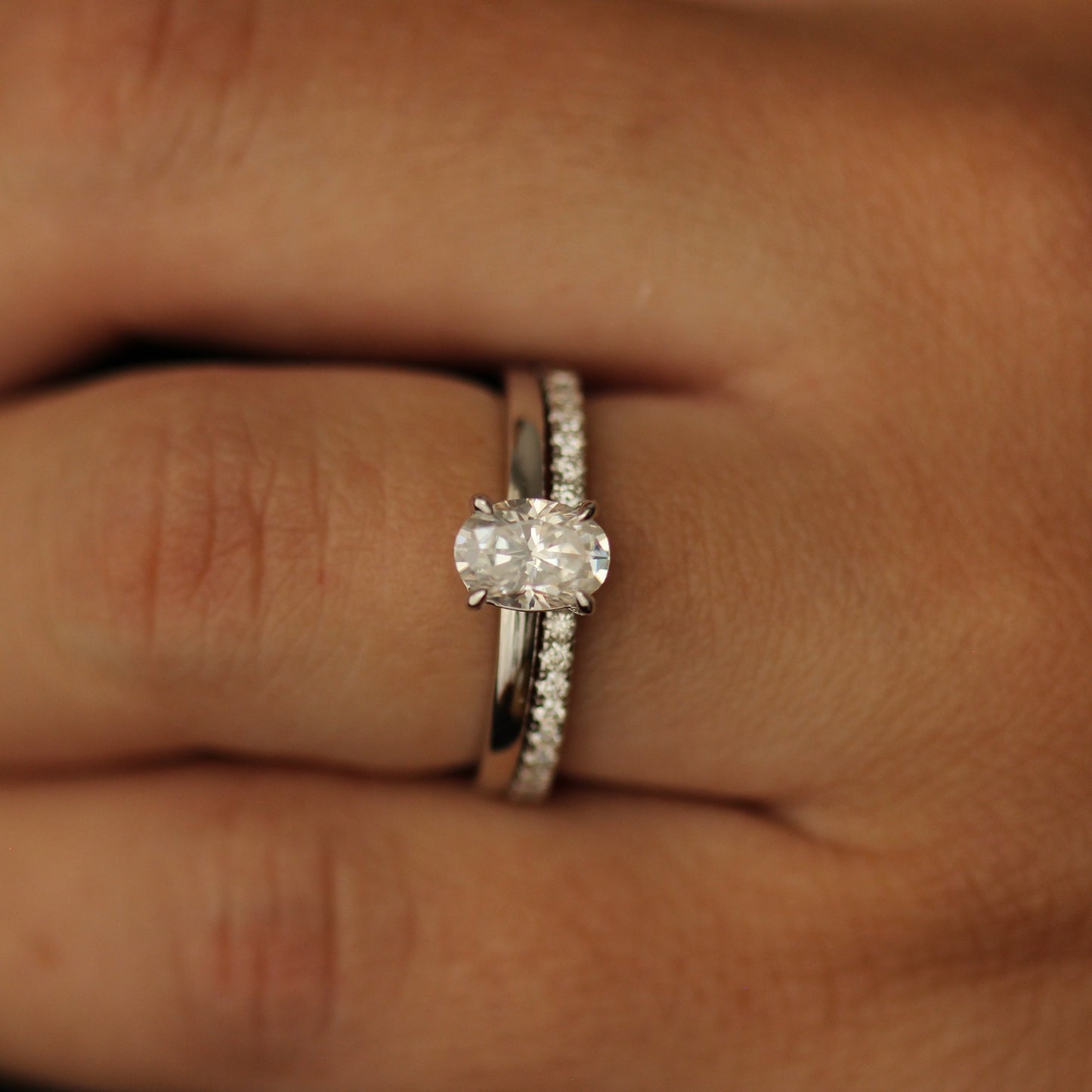 1 carat oval moissanite ring stacked with a half pavé band